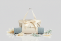 Beige tote bag with a blue yoga mat on a light gray background